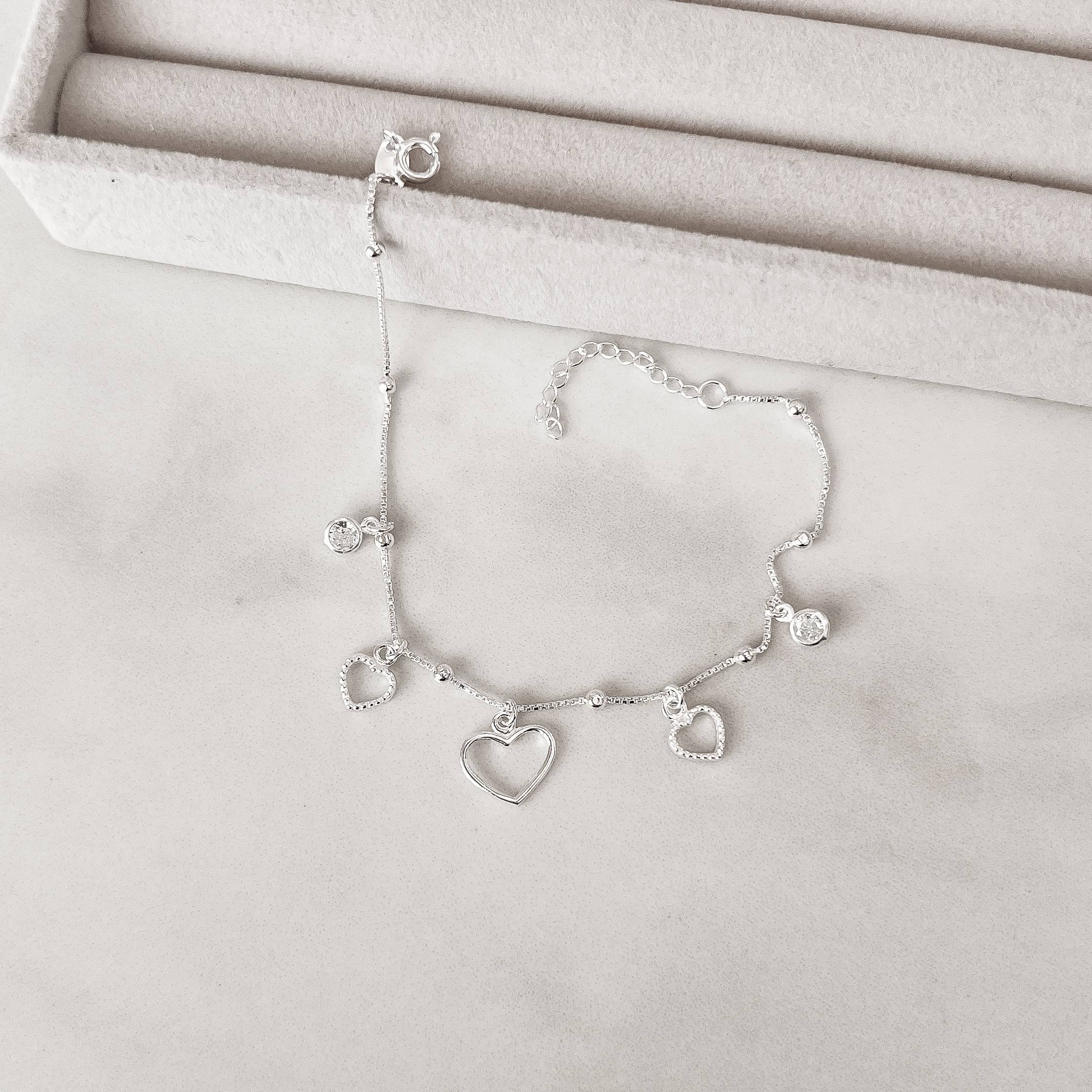 Pulseira entremeio bolas com pingentes corações vazados e zircônias