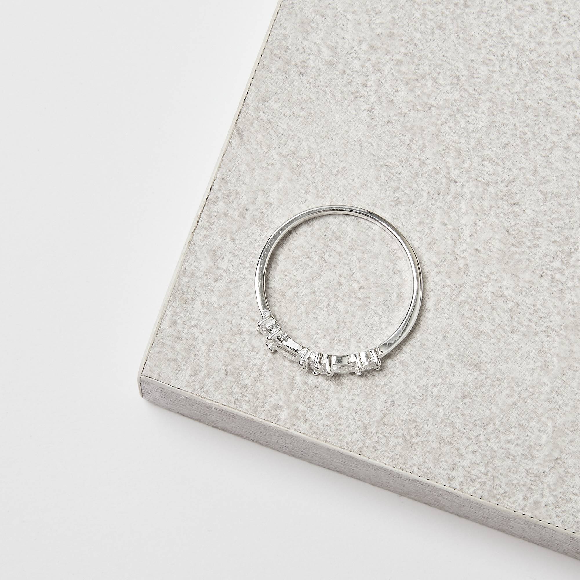 Imagem Secundária Anel meia aliança cravejada de zircônias redonda, retangular e navete