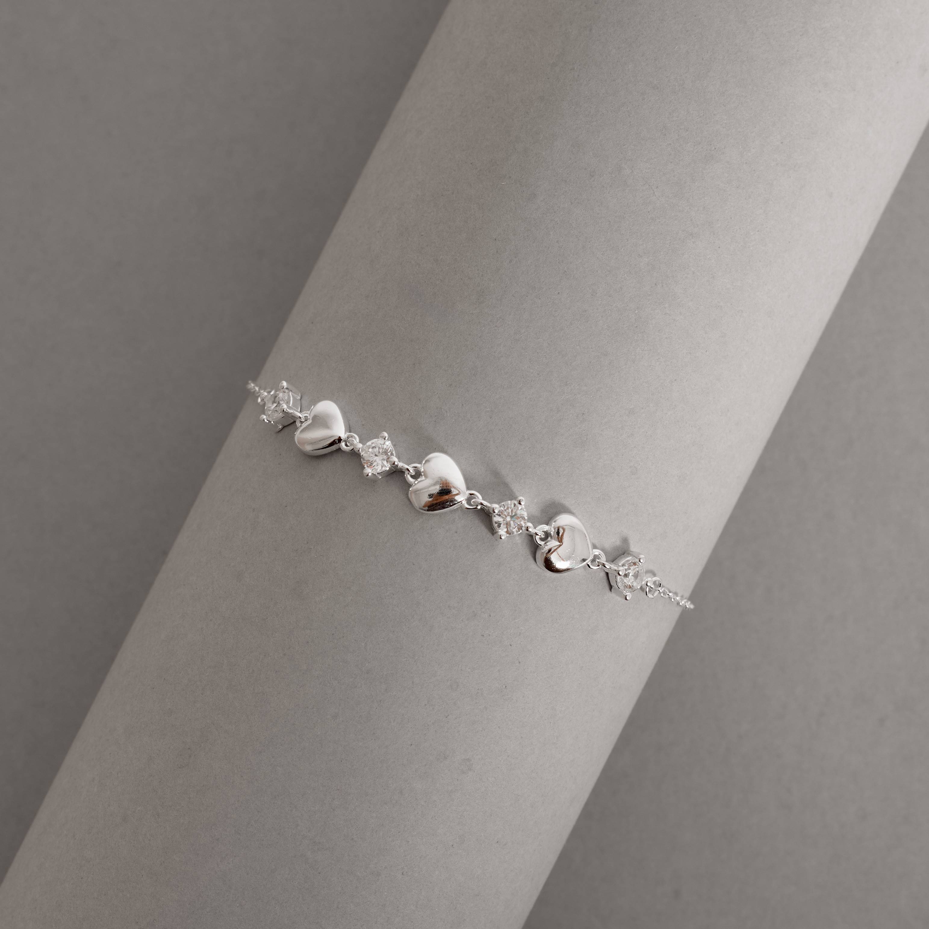 Imagem Secundária Pulseira entremeios zircônias e corações 16+4cm