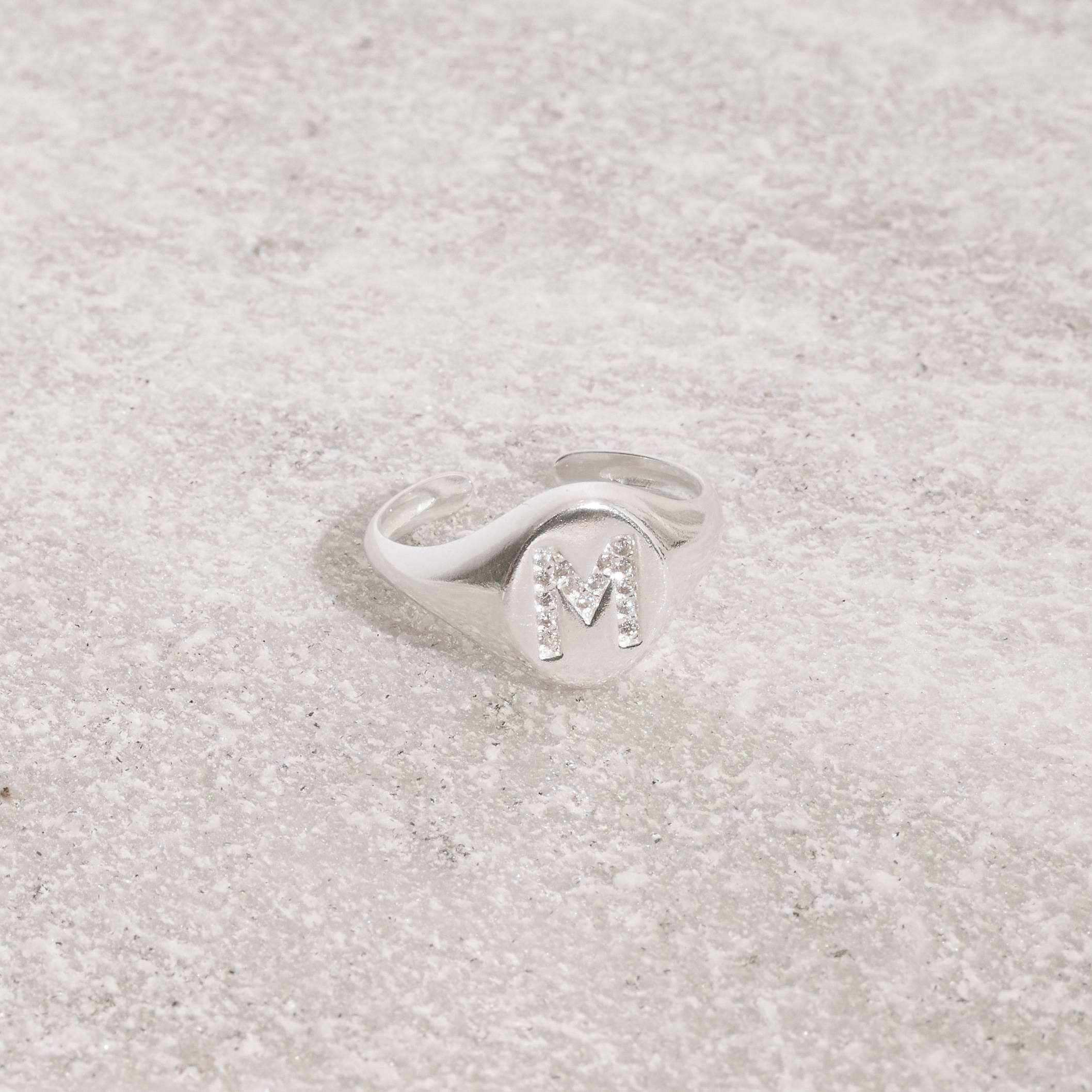 Anel oval letra M cravejada regulável P